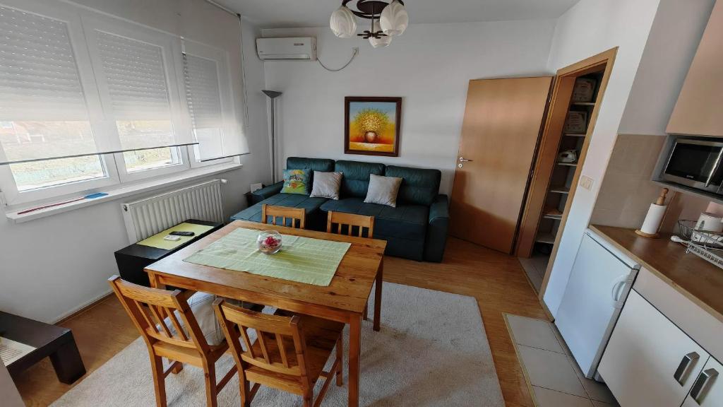 a living room with a table and a couch at Maslačak, dvosobni in Banja Koviljača