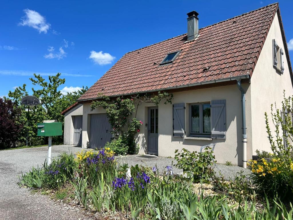a white house with flowers in front of it at Aux Forts Champs in Vouhenans