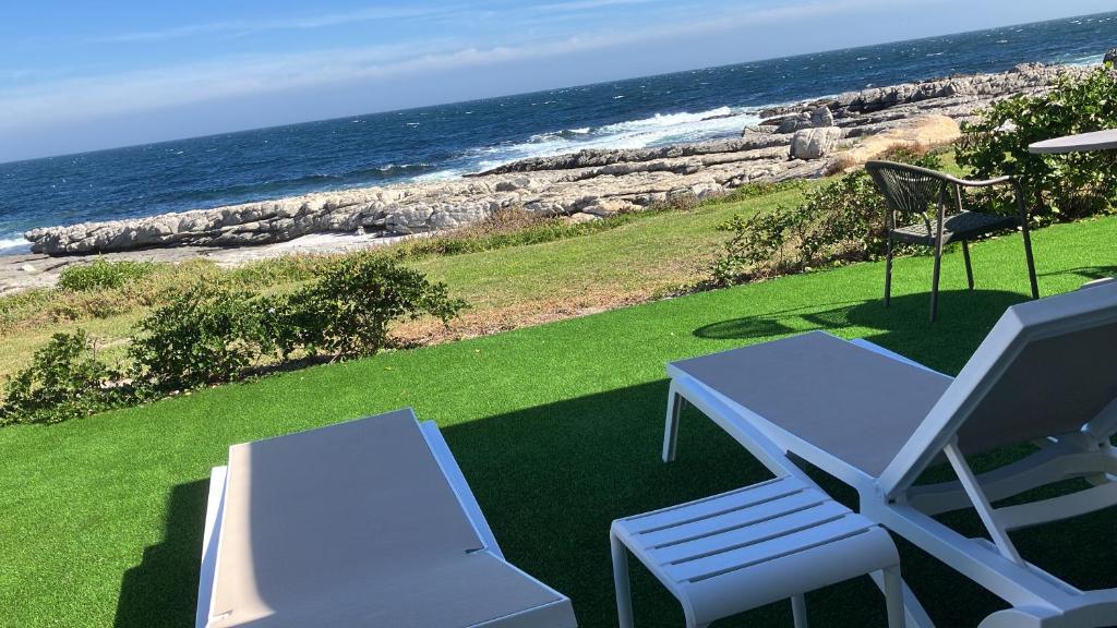 a white table and two chairs and the ocean at Hermanus Oceanbay View in Hermanus