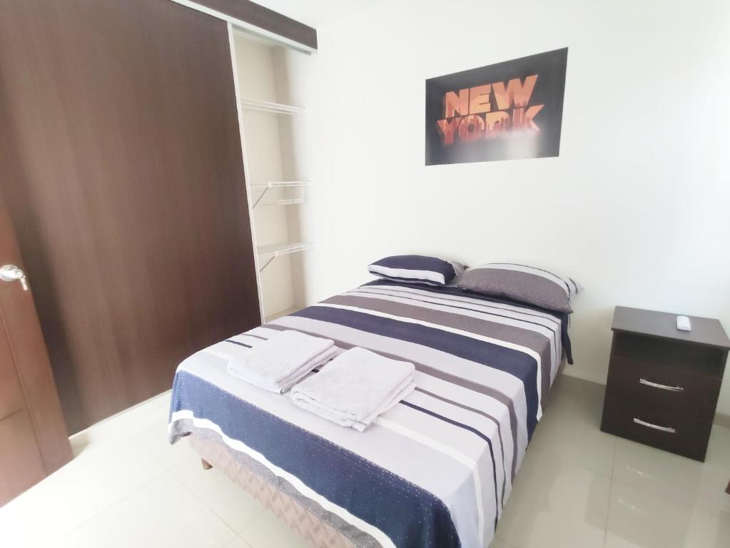 a bedroom with a bed with a blue and white blanket at Mi casa, moderna B in Vila El Carmen
