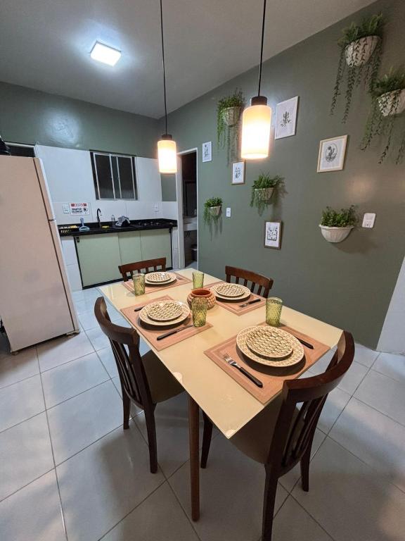 a dining room table with chairs and a kitchen at Residencial Junino do Mestre - Casa 66 in Caruaru
