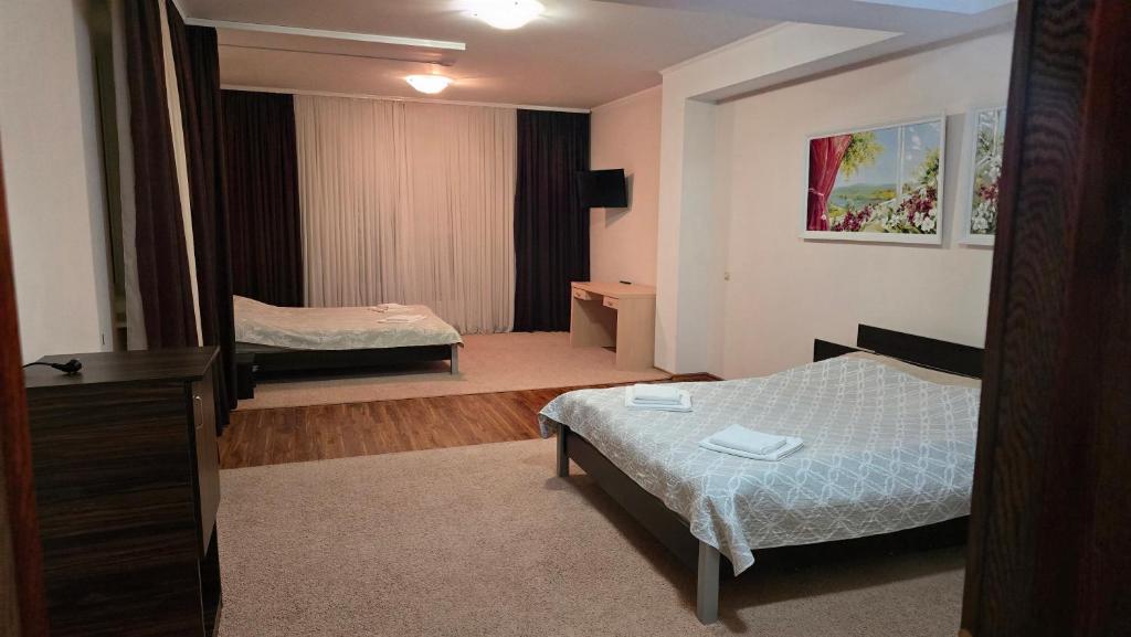 ein Zimmer mit zwei Betten und einer Kommode in der Unterkunft Grace Villa in Codru