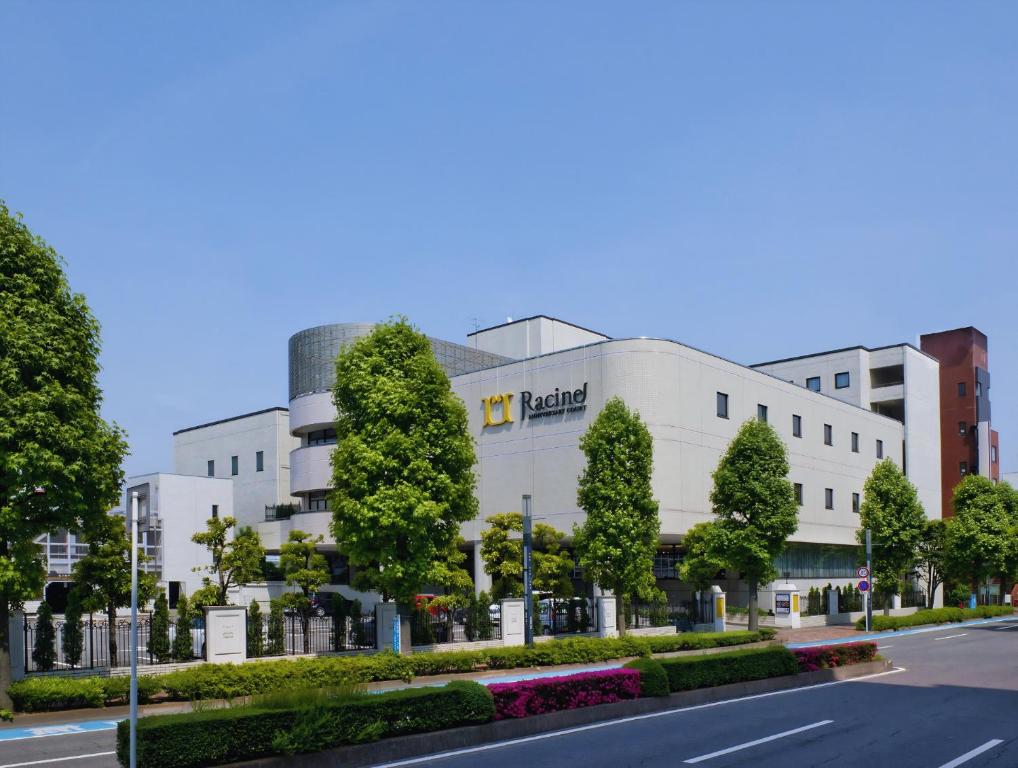 a large white building with a sign on it at Racine Shinmaebashi in Maebashi