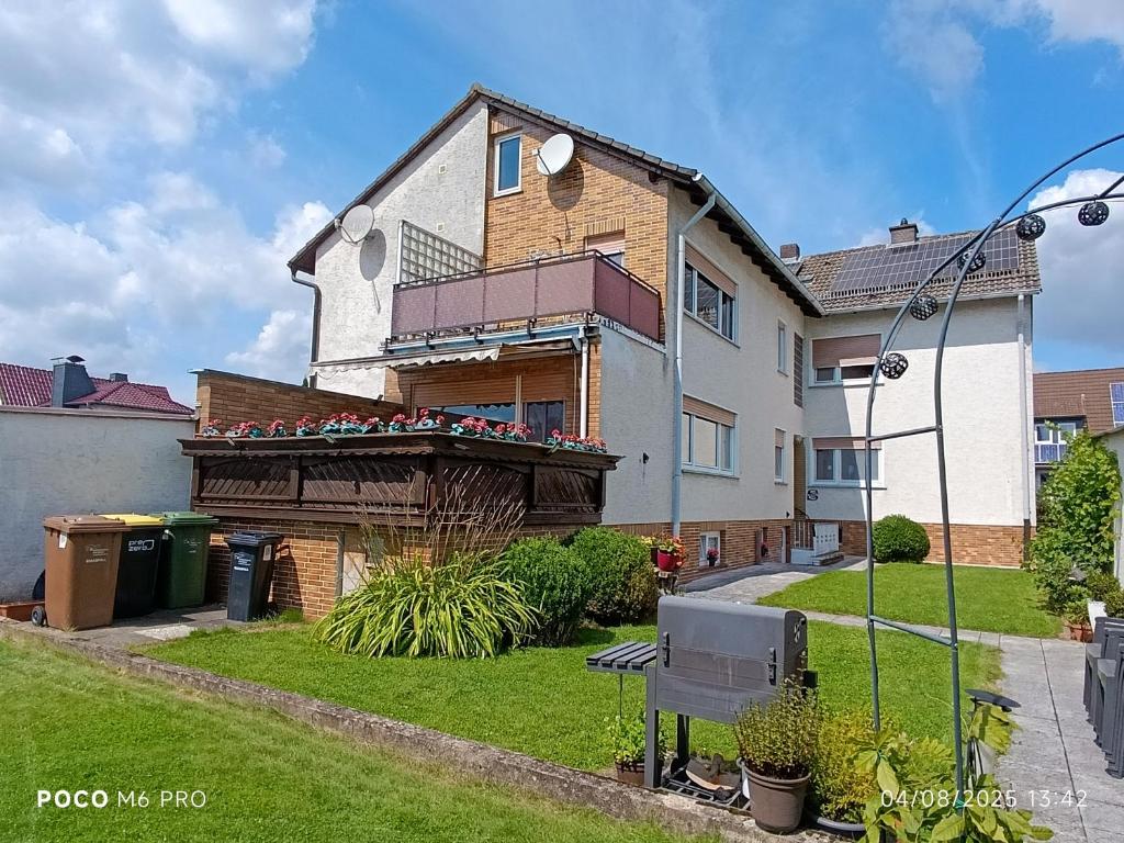 a house with a balcony with chairs on it at Ferienwohnung in Espenau