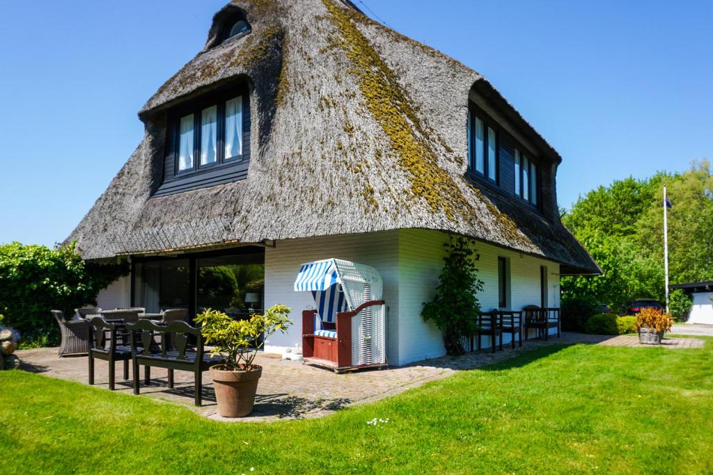 a thatch roofed house with a thatched roof at Uaster Reeg III Studio in Archsum