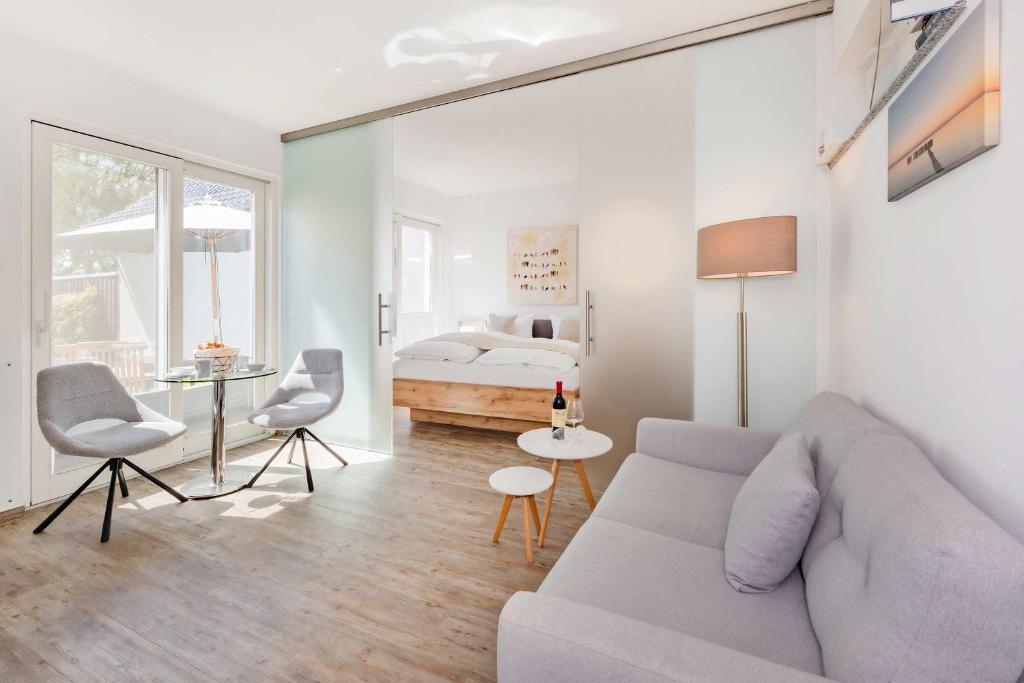 a white living room with a couch and a bed at Ferienhaus Kuschelnest in Kamminke