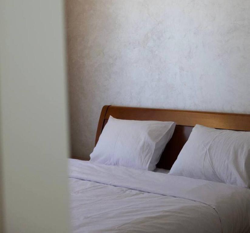 a bed with white sheets and two pillows at СічSich in Kolomiya