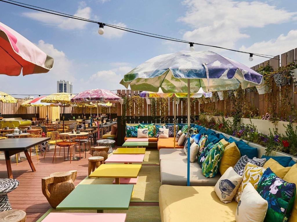 a patio with couches and tables and umbrellas at Mama Shelter Paris East in Paris