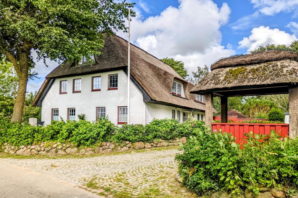 a large white house with a thatched roof at Seestern in Vollerwiek