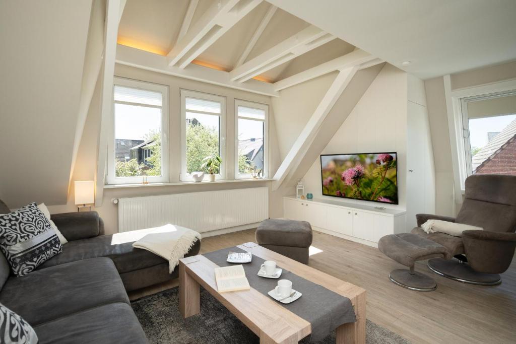 a living room with a couch and a tv at Silwai OG in Westerland