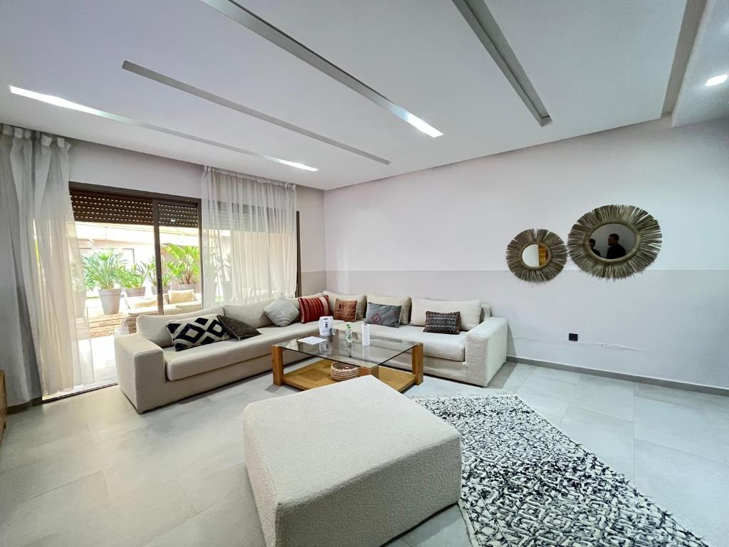 a living room with a couch and a table at Charming Seaside Apartment with Pool & Direct Beach Access in Agadir nʼ Aït Sa