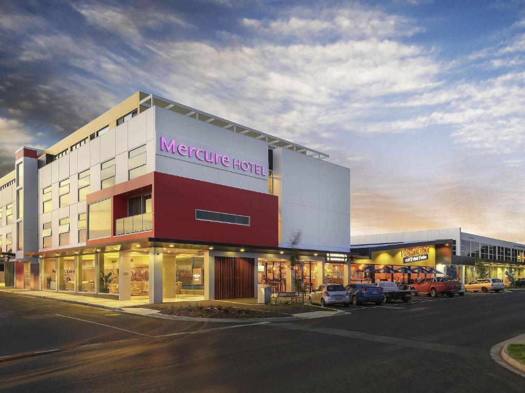 a large building with a store in a parking lot at Mercure Warragul in Warragul