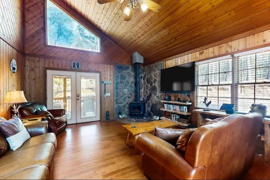 a living room with leather furniture and a tv at Coos Moose in Ellijay