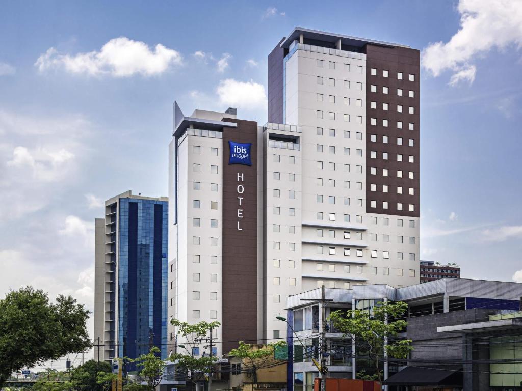 a tall white building with a sign on it at ibis budget Manaus in Manaus
