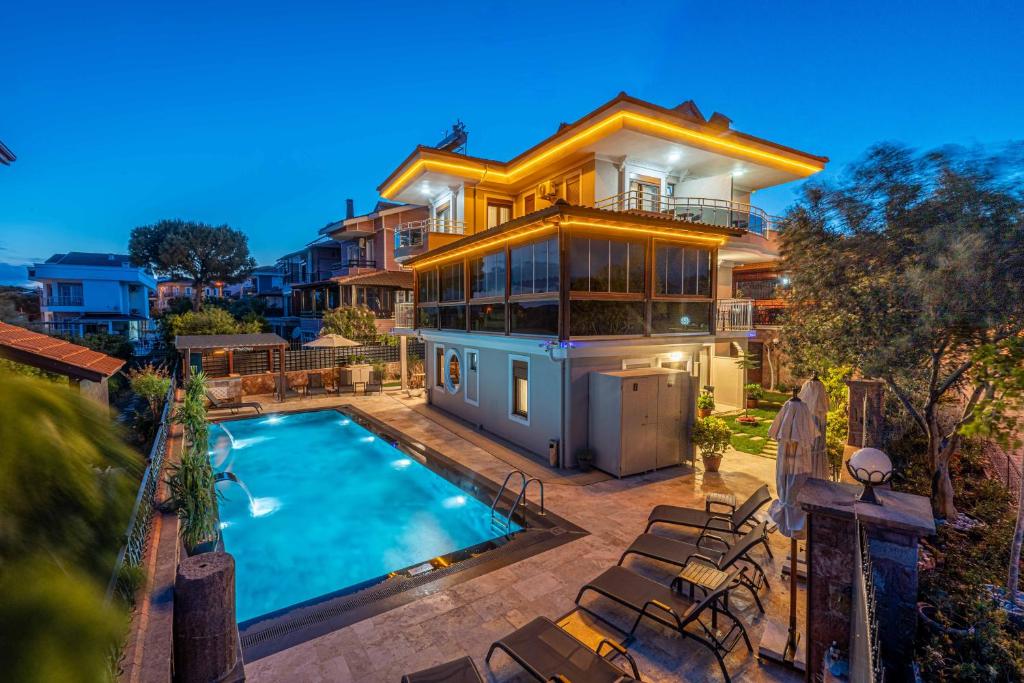 a large house with a swimming pool in front of it at Rumet Cunda Otel in Ayvalık