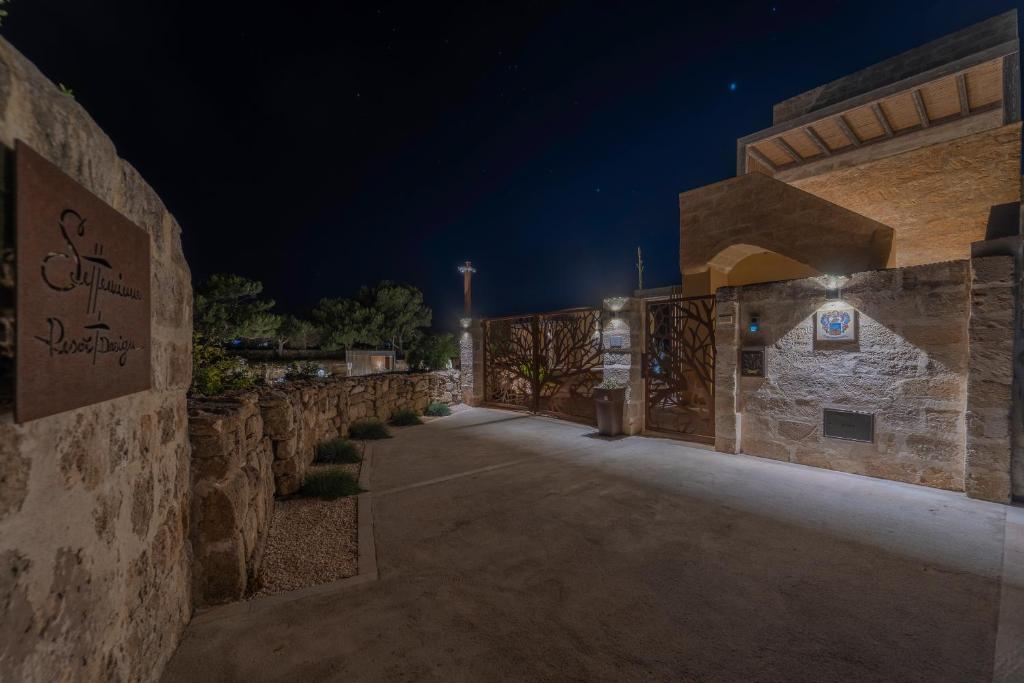 a building with a stone wall at night at Setteminne Resort Design in Favignana