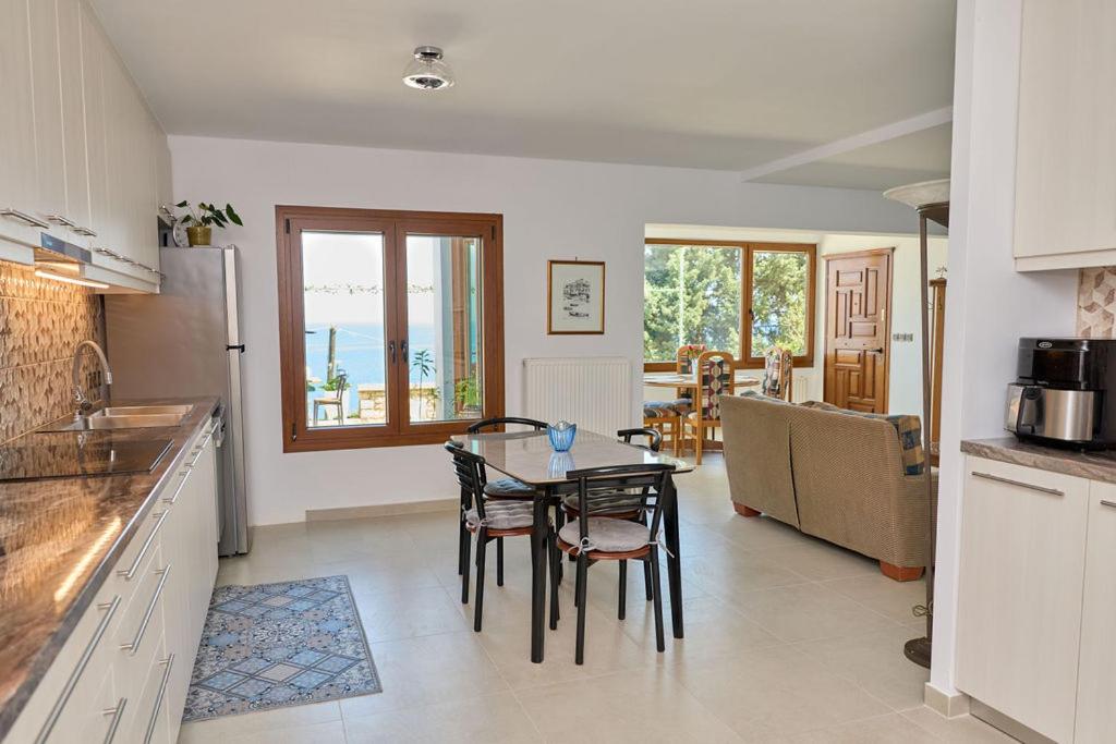 a kitchen and dining room with a table and chairs at 180 View Private 2 Bedroom Seaview Home in Samos