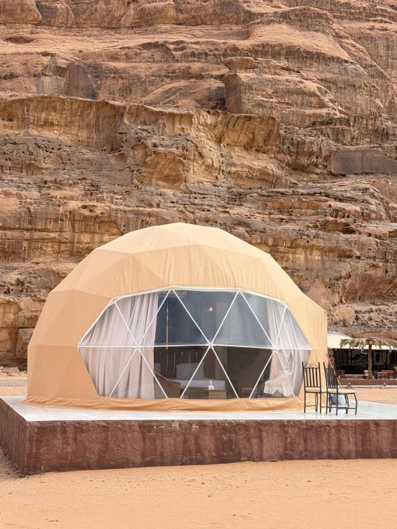 a tent with a table and chairs in the desert at Norita Luxury Camp in Wadi Rum