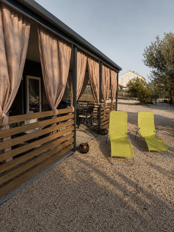 two green chairs sitting outside of a cabin at SevenSeasCove in Sukošan