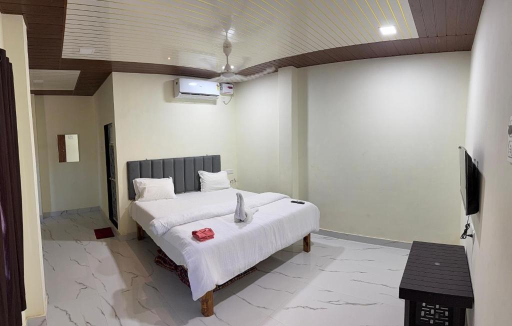 a bedroom with a bed and a flat screen tv at Om residency in Diveagar