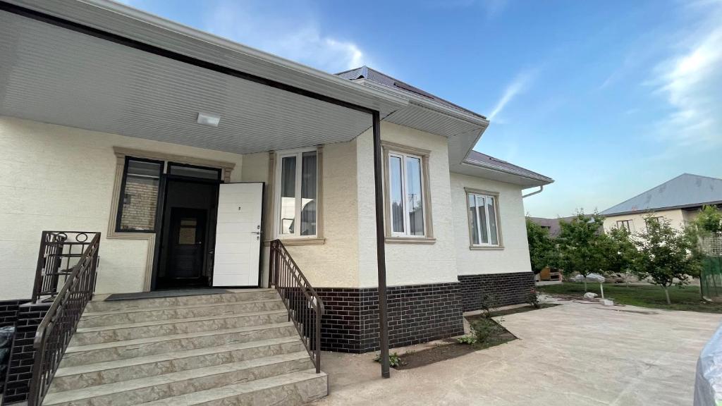 a house with a black roof and stairs at Guest Home in Jalal-Abad