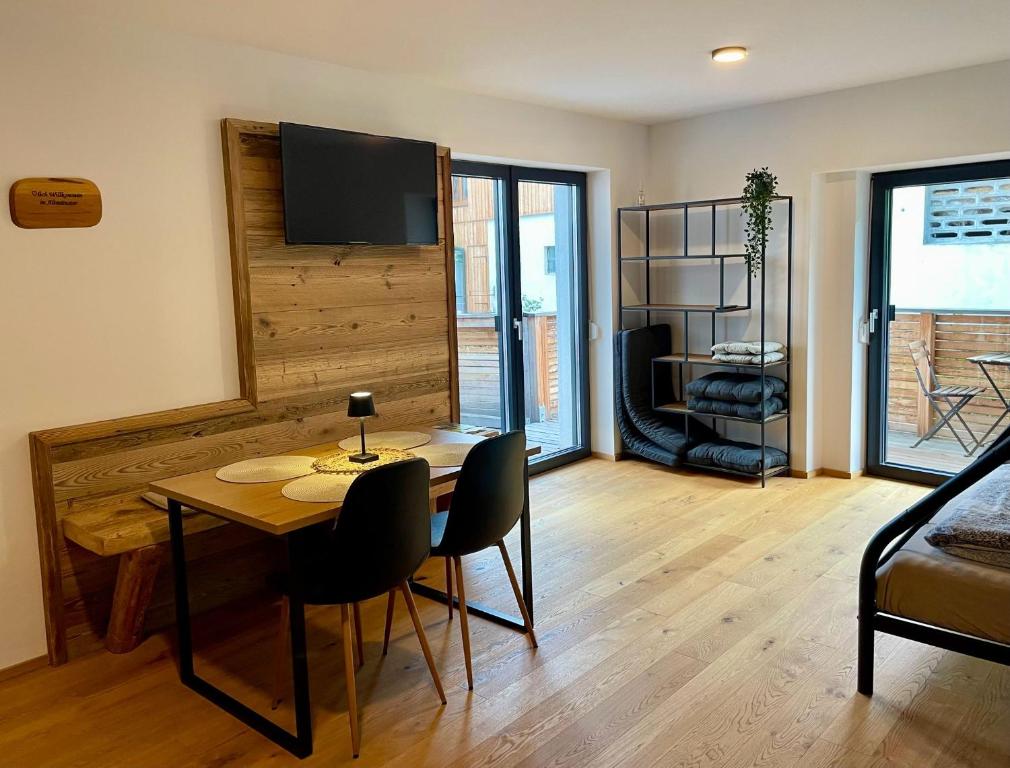 a living room with a table and chairs and a television at Rittertal-Altholzseeblick in Altmünster