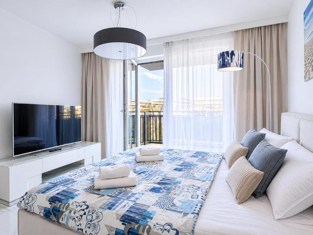 a living room with a large bed and a tv at BelMare Seaside Apartment by Solarento in Międzyzdroje