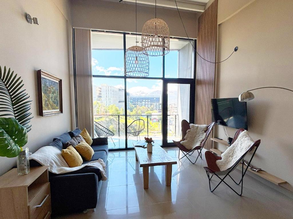 a living room with a couch and a large window at Kóor Stays - Australis in Ushuaia