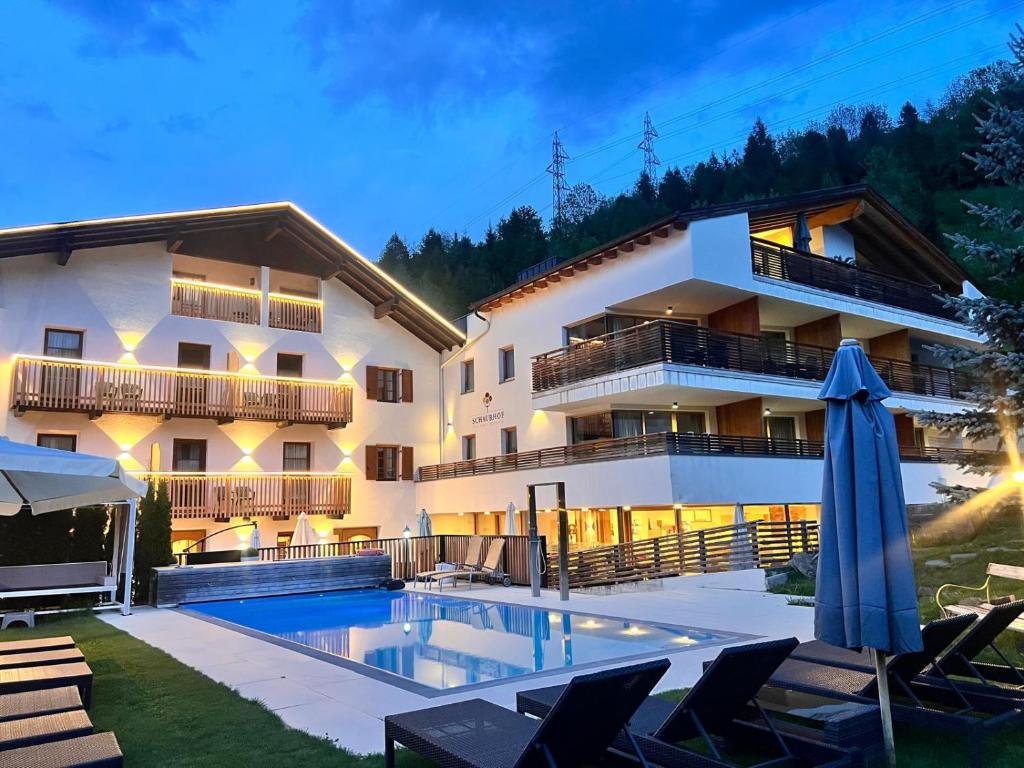a hotel with a swimming pool in front of a building at Hotel Restaurant Schaurhof in Vipiteno