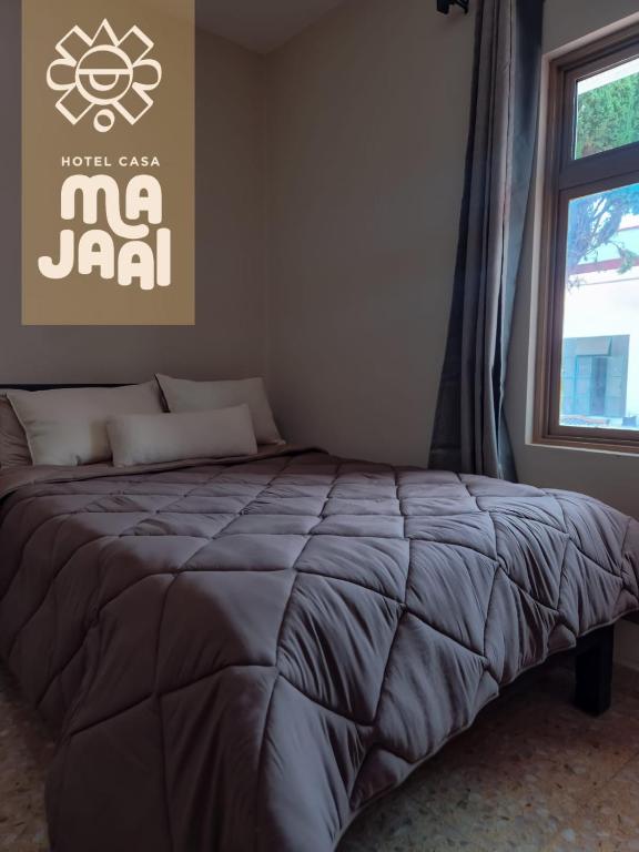 a bed in a room with a window at Hotel Casa Majaal in Ixtapan de la Sal
