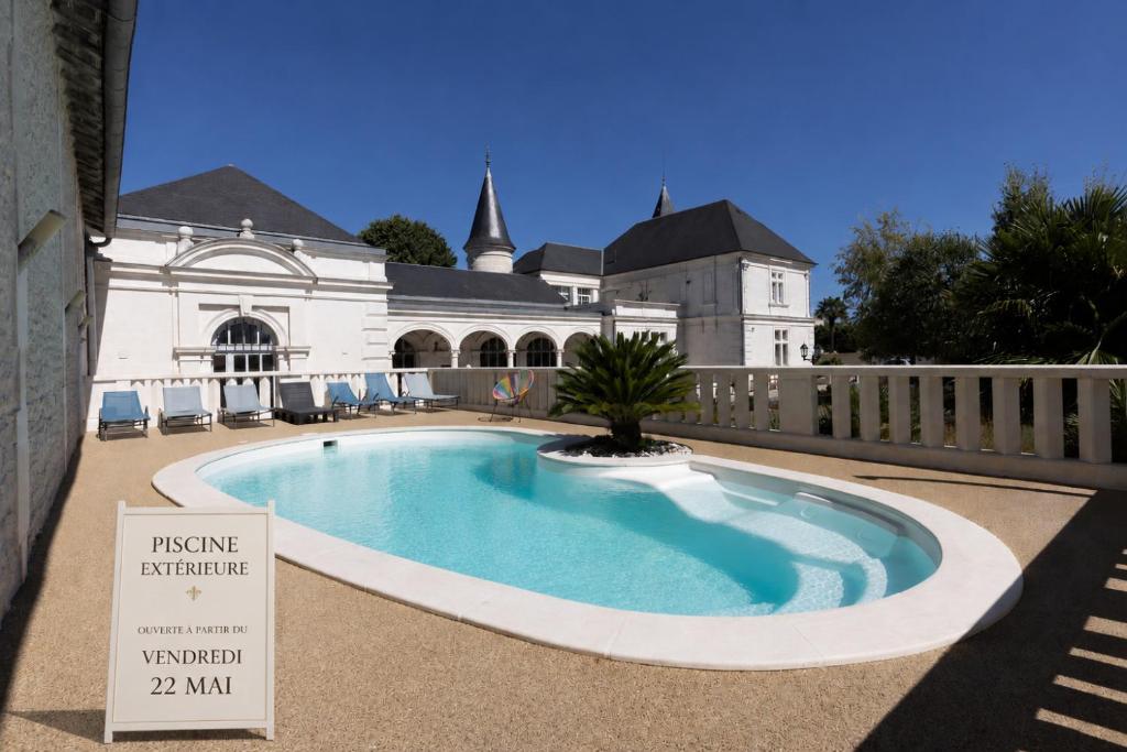 a swimming pool with a sign in front of a building at Château Pellisson in Cognac