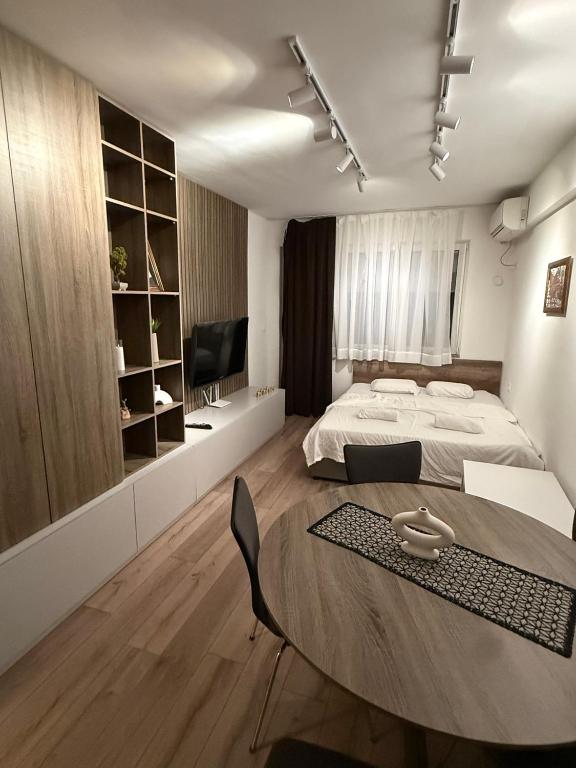 a bedroom with a bed and a table and a television at NeWave Apartment 2 in Strumica