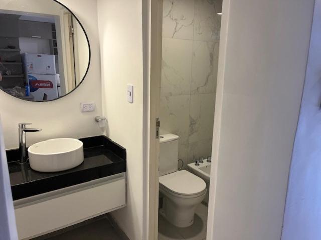 a bathroom with a sink and a toilet and a mirror at Yerba Buena House in Yerba Buena
