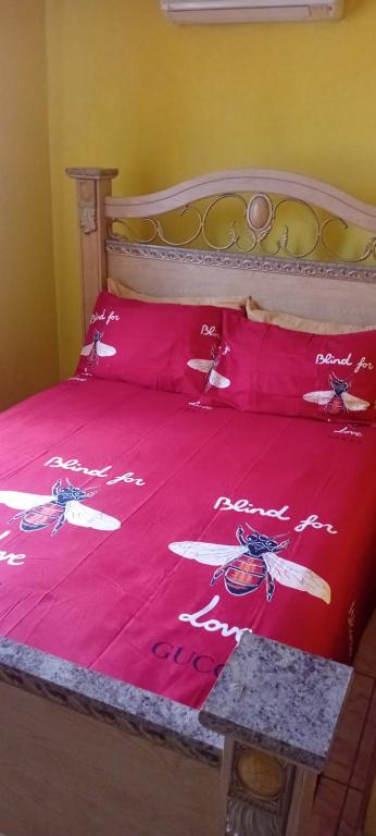 a bed with a red bedspread with drones on it at Paradise treasure view in Montego Bay