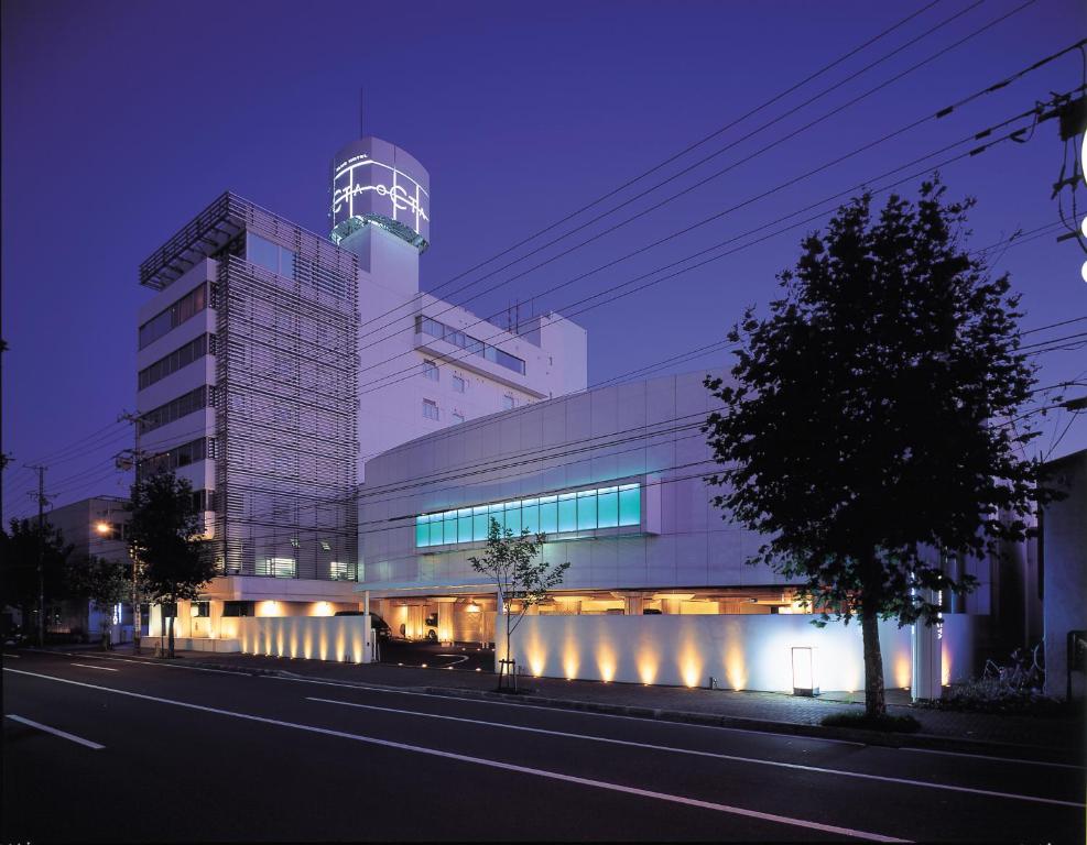 un edificio con una torre sopra di essa di notte di Blue Hotel Octa (Adult Only) a Sapporo