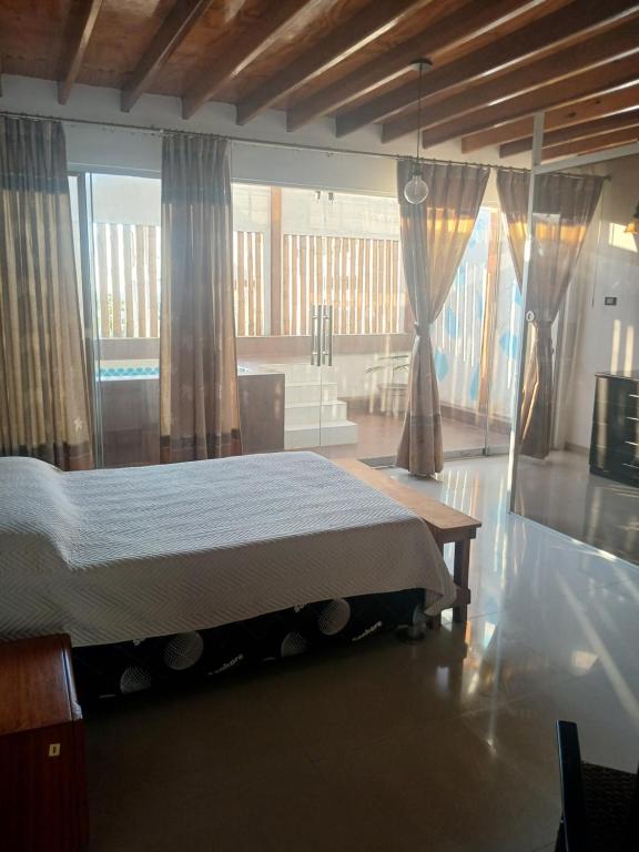 a bedroom with a bed and a large window at Casa Berenice in Zorritos