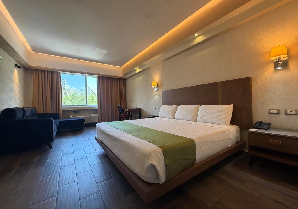 a hotel room with a large bed and a window at Hotel Diana del Bosque by DOT Urban in Morelia