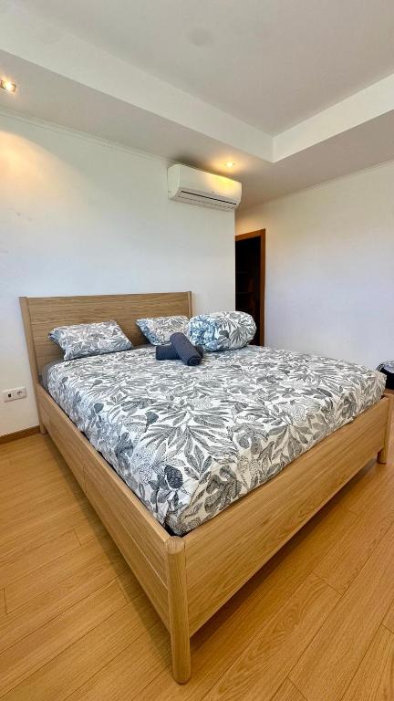 a bedroom with a large bed with a wooden frame at Aqui é o seu lugar. in Bobadela