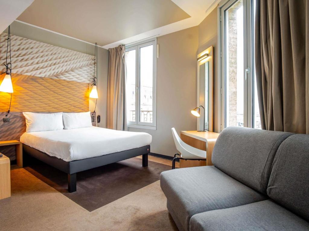 a hotel room with a bed and a couch at ibis Bordeaux Centre Gare Saint Jean Euratlantique in Bordeaux