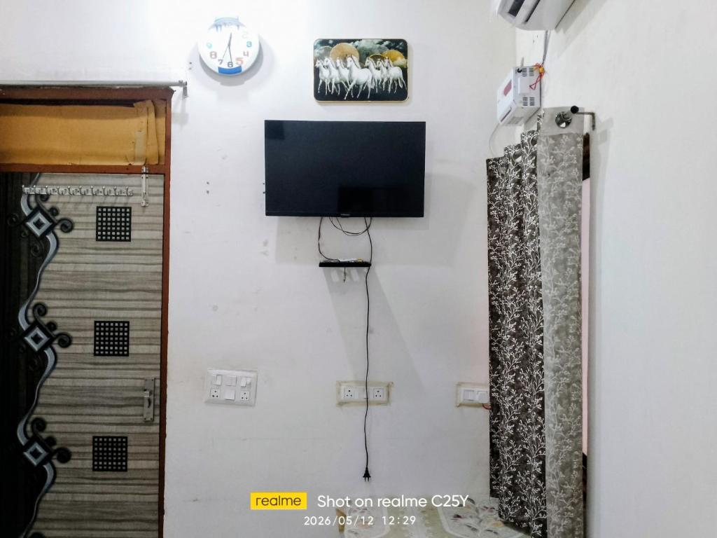a room with a tv on a wall at Radha Rani homestay in Vrindāvan