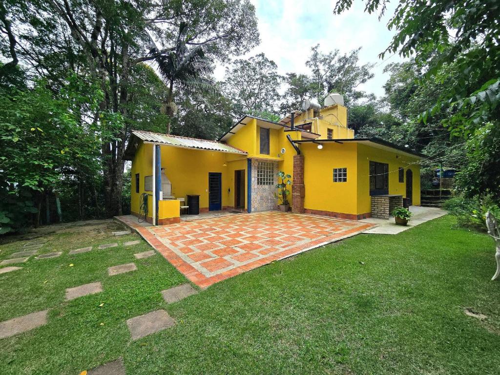 a yellow house with a brick yard in front of it at Casa Amarela, Refúgio na natureza Rota do vinho in São Roque
