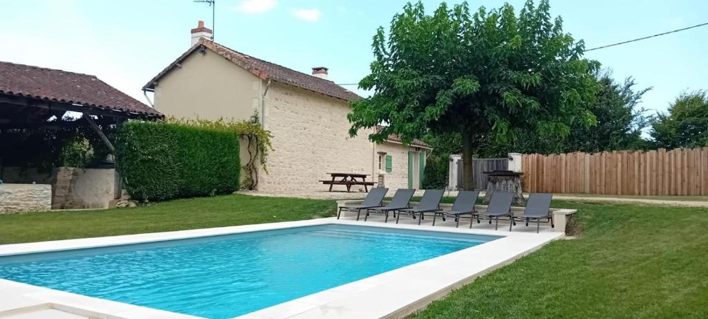 a pool in a yard with chairs and a table at Maison Brunetière in Saint-Martin-lʼArs
