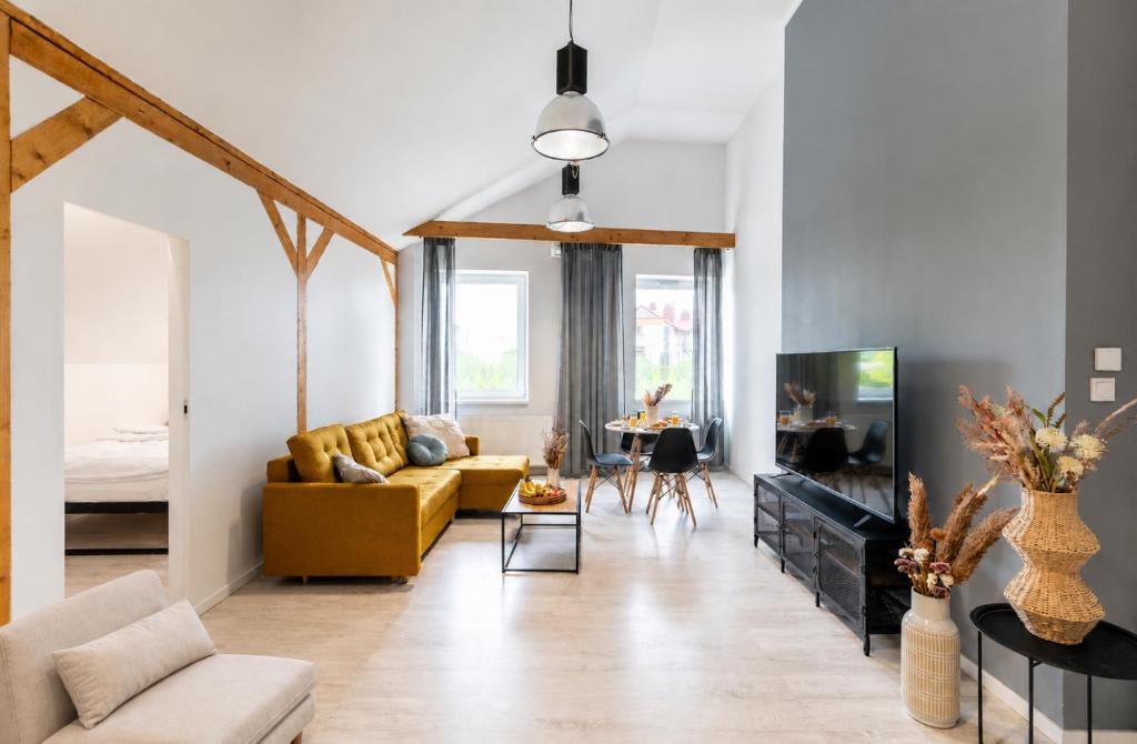 a living room with a yellow couch and a tv at Apartment Quiet Street 11/7E in Oświęcim