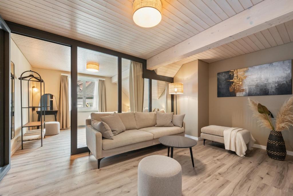 a living room with a couch and a table at Interalps - AlpsView Premium Apartments Altdorf - Free Parking - AC in Altdorf