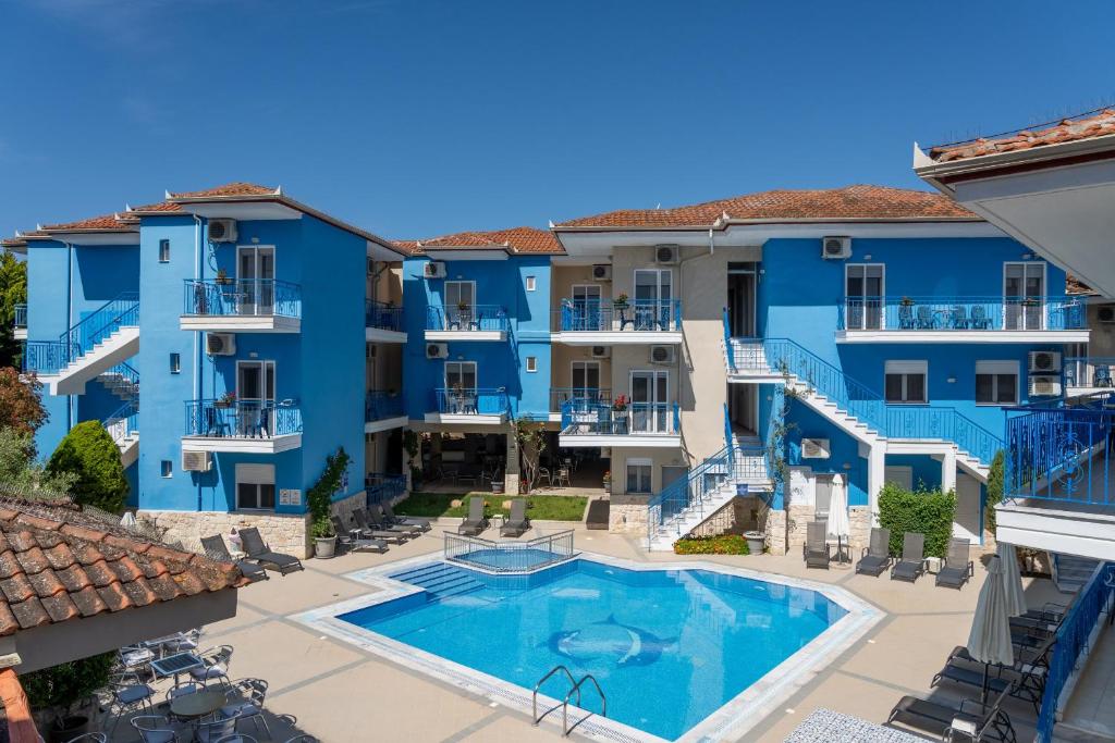 Blick auf den Innenhof eines blauen Wohnhauses mit Swimmingpool in der Unterkunft Stratos Hotel in Afytos