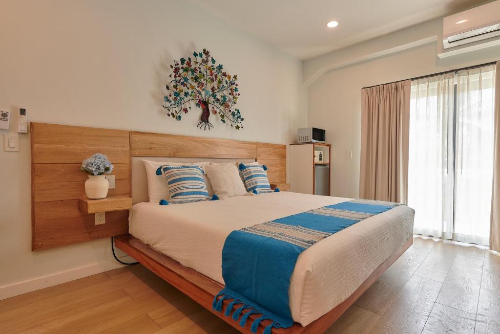 a bedroom with a large bed with a wooden headboard at Hotel Fusión in Puerto Escondido