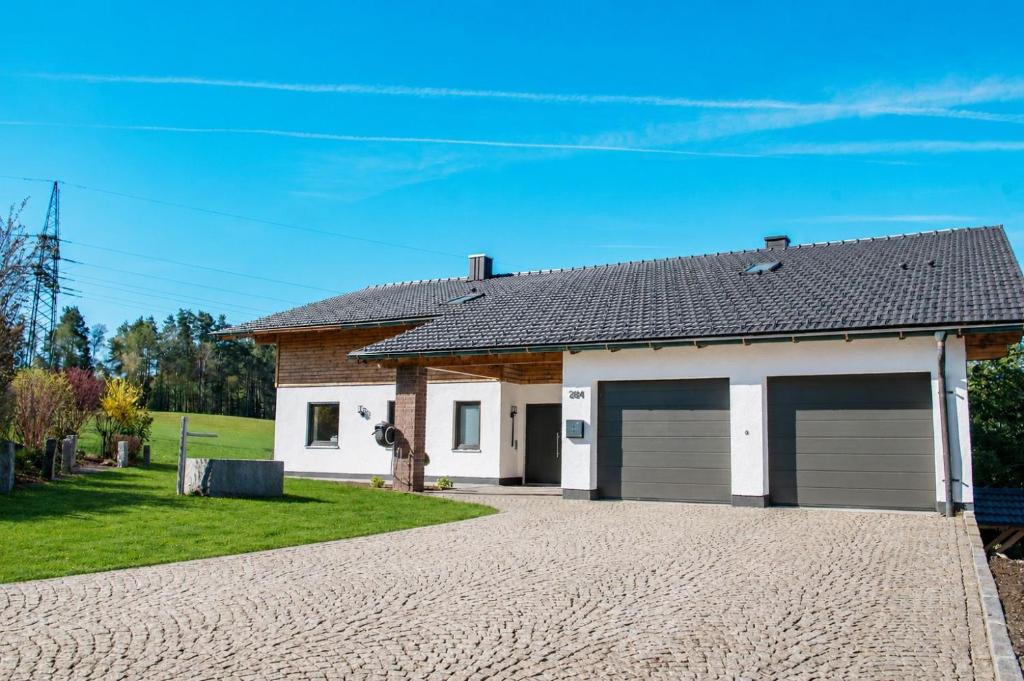 a house with two garage doors in a driveway at Ferienwohnungen Kreuzer in Regen