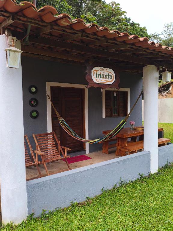 a porch of a house with a table and chairs at Chalé Triunfo in Pacoti