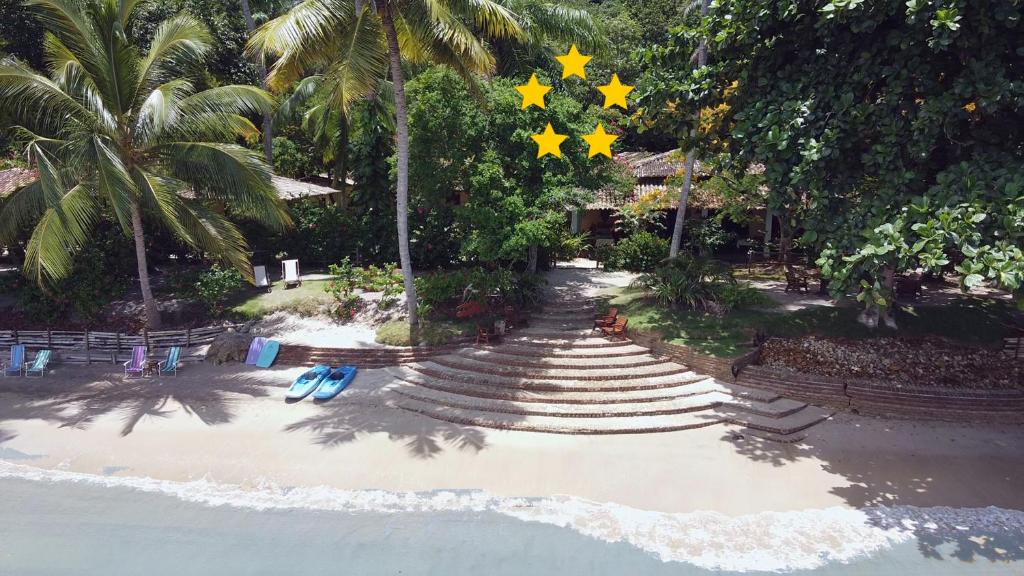 a beach with chairs and stars hanging from trees at POUSADA TASSIMIRIM - Tranquilidade em frente ao Mar in Ilha de Boipeba