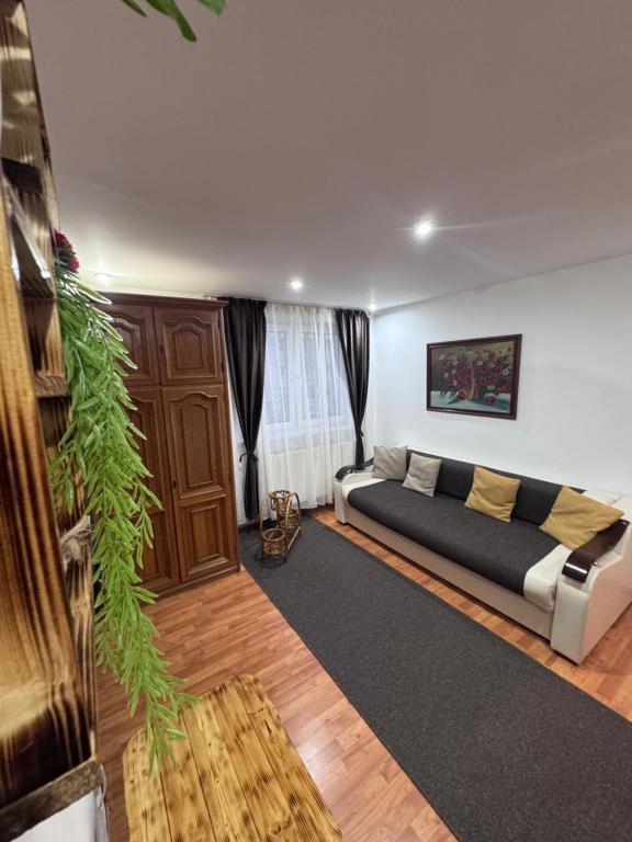 a living room with a bed and a plant at Rustic Paradise Turda in Turda